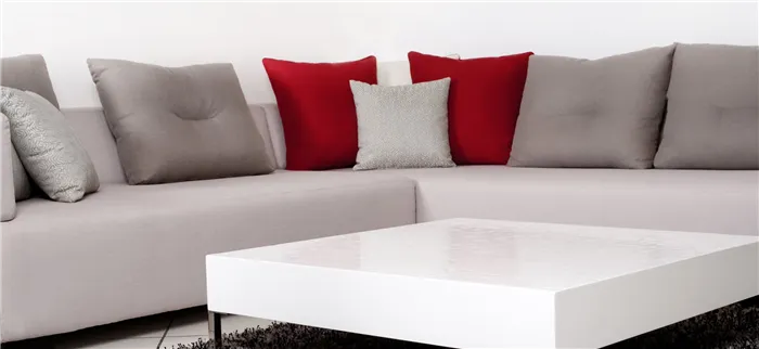 Яркие красные подушки станут акцентным декором на сером диване