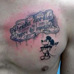 Тату на груди парня - мышь Микки Маус и надпись
