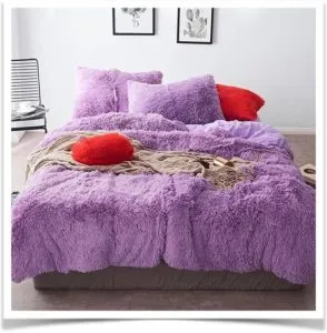 Кровать с сиреневым покрывалом и подушками