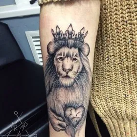 Татуировка на предплечье у девушки - лев с короной