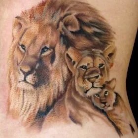 Тату на спине девушки - лев, львица и львенок