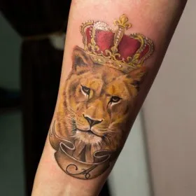 Татуировка на предплечье у парня - лев с короной