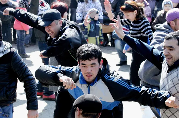 Молодые люди танцуют во время празднования Навруза