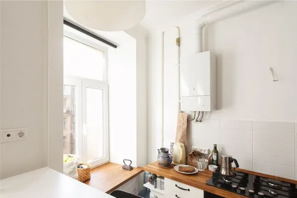 Белый газовый котел на стене современной кухни