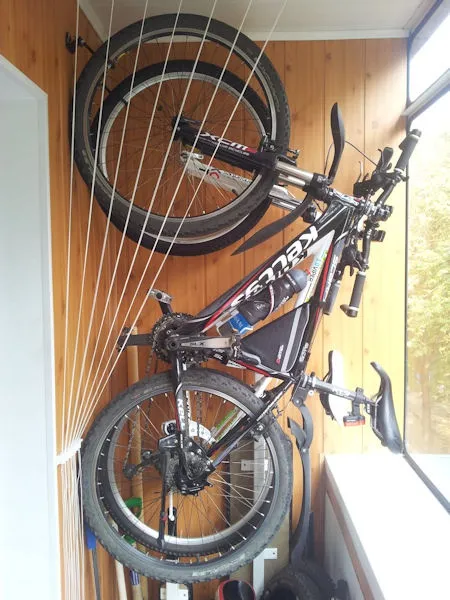 фото: хранение велосипеда на крюках на балконе